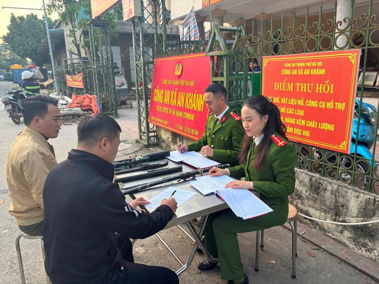 Cán bộ Công an xã An Khánh lập biên bản tiếp nhận súng săn, dao kiếm tự chế do người dân tự giác giao nộp.
