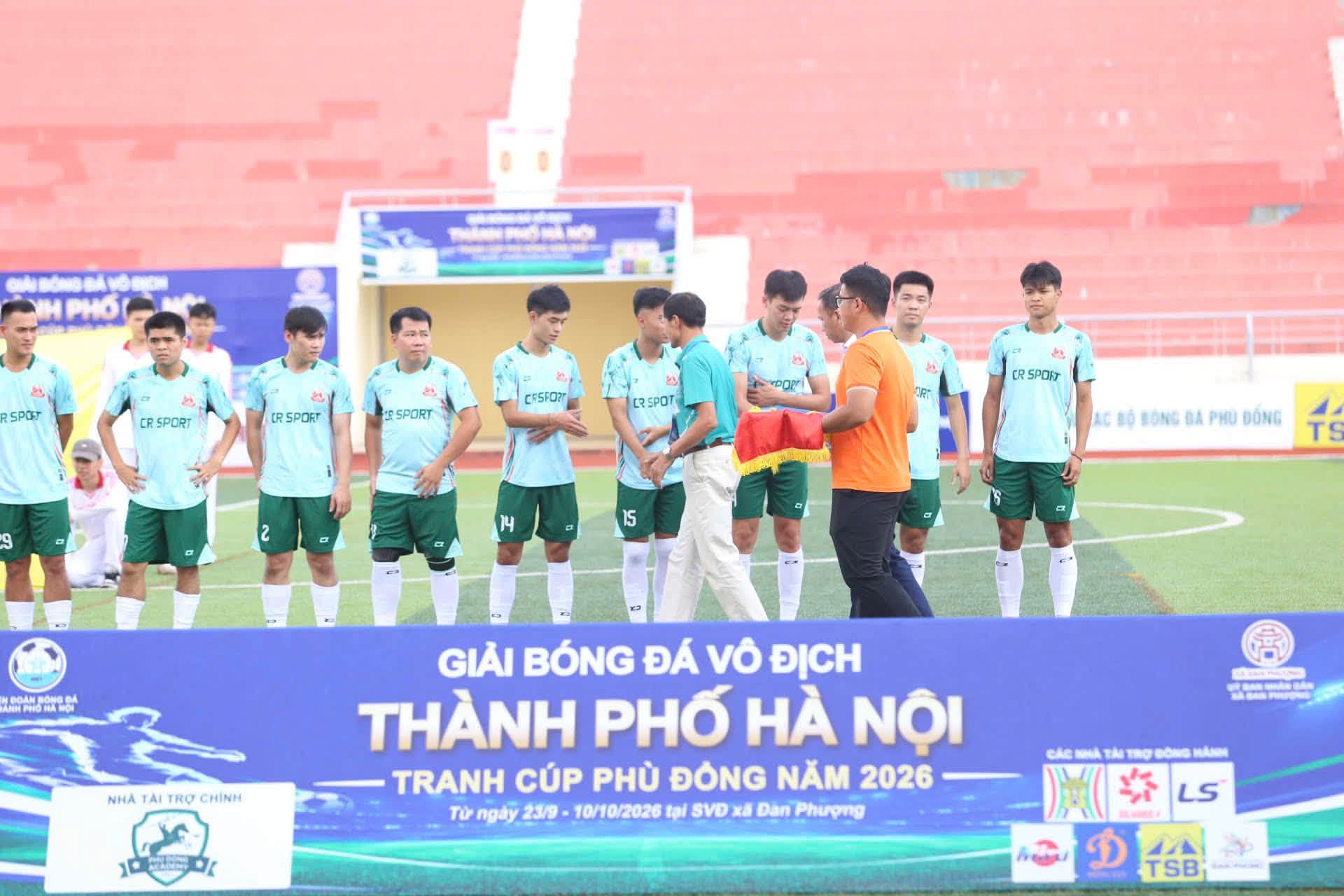 Ban tổ chức giải bóng đá Vô địch thành phố Hà Nội trao cờ lưu niệm động viên tinh thần thi đấu của các cầu thủ.