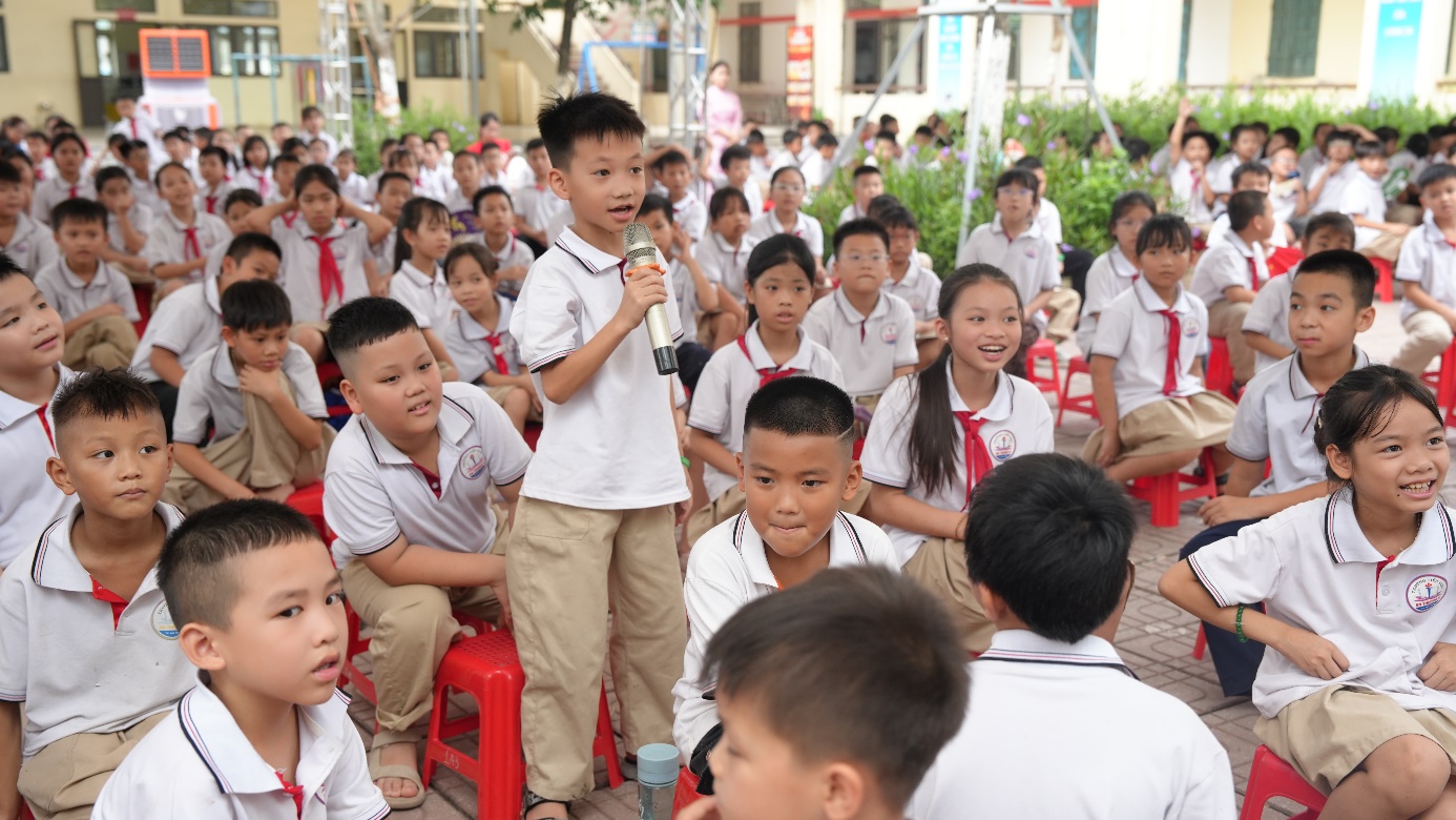 Học sinh hào hứng giơ tay trả lời các câu đố khoa học trong phần thi MiniGame do Đại học Ngoại thương đồng hành.