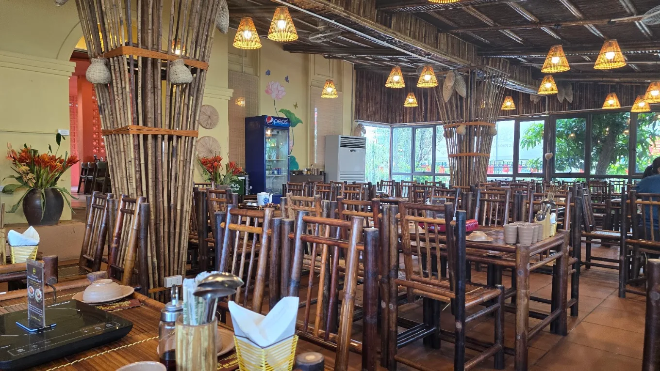 Khu vực sảnh chính rộng rãi, sạch sẽ với nội thất bàn ghế tre mộc mạc và hệ thống đèn lồng mây tre tinh tế.