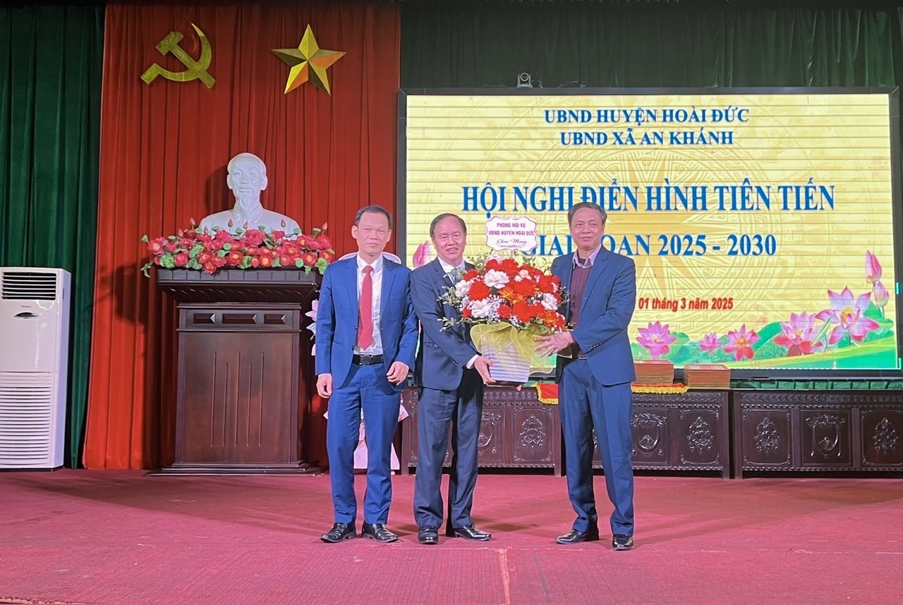 Đại diện lãnh đạo phòng ban chuyên môn huyện tặng hoa chúc mừng Hội nghị Điển hình tiên tiến xã An Khánh.