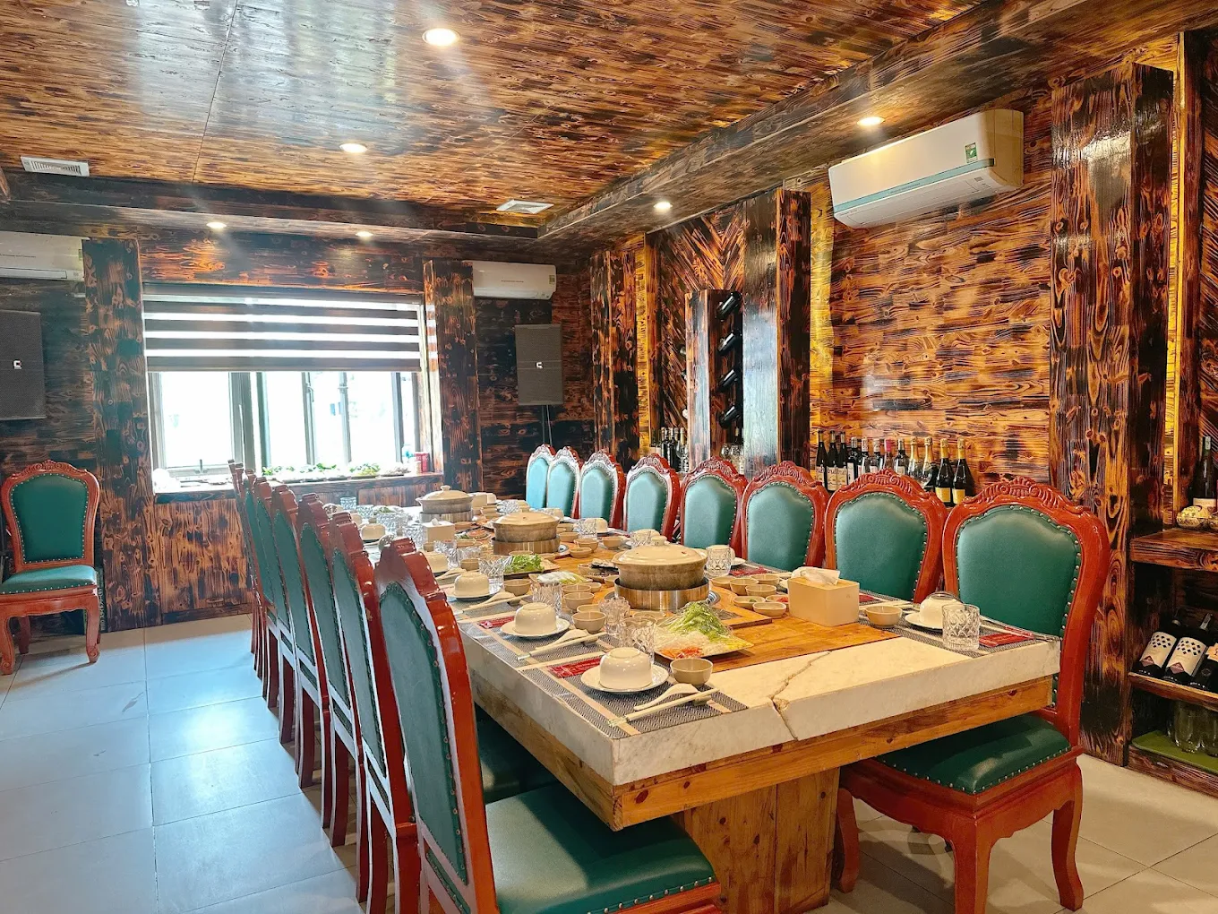 Không gian phòng VIP đẳng cấp với bàn tiệc lớn bằng đá, vách gỗ ấm cúng phục vụ các buổi tiệc riêng tư.