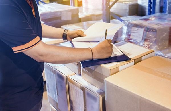 Nhân viên kho kiêm giao hàng tại Công ty Minh Nhật thực hiện việc đối chiếu mã kiện và chứng từ trước khi xuất bãi.