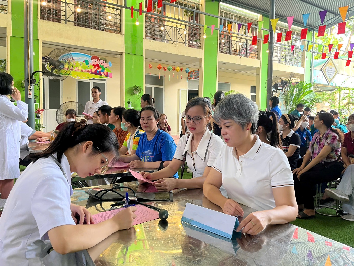 Đồng chí Bùi Thu Hương - Phó Chủ tịch UBND xã trực tiếp có mặt tại bàn khám sàng lọc để động viên tình nguyện viên.