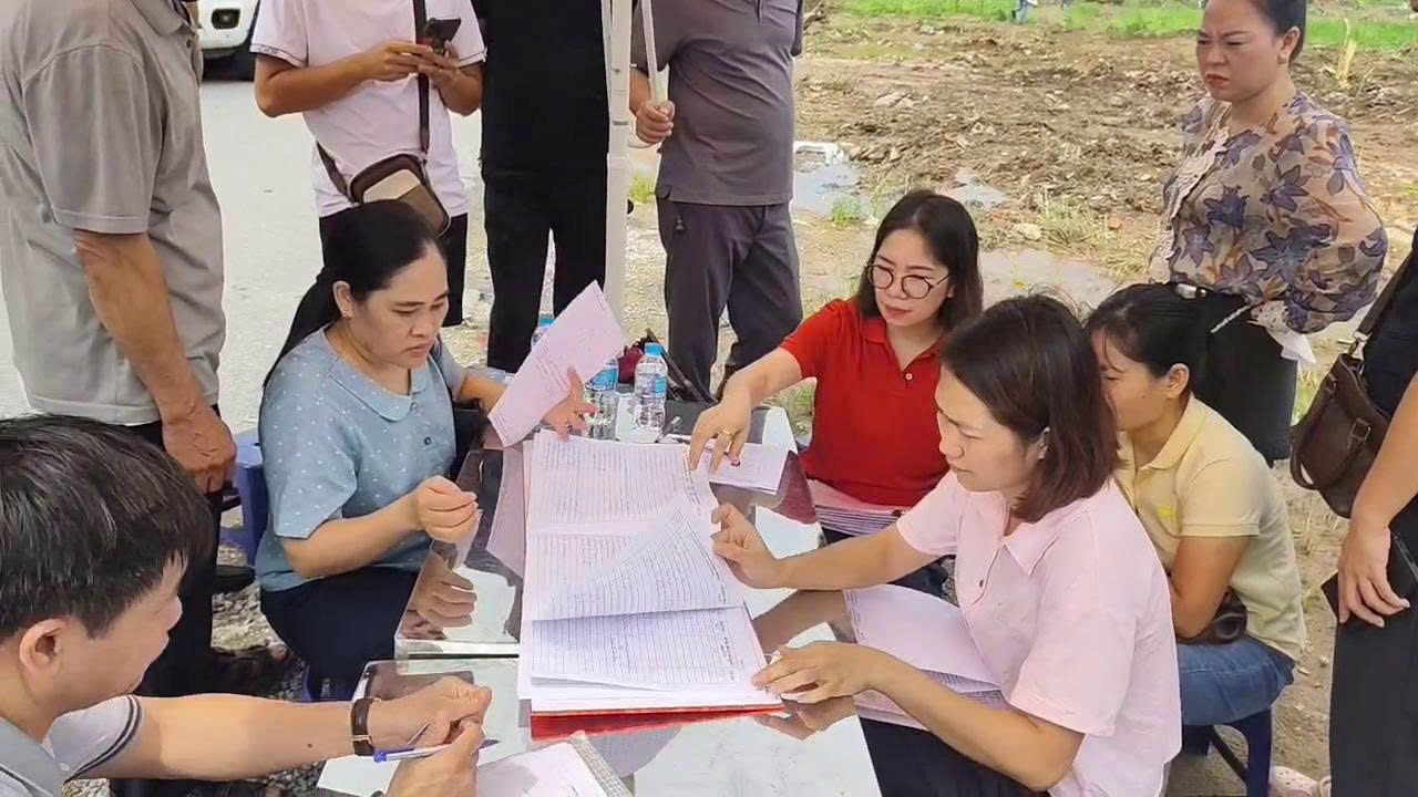 Người dân phấn khởi ký biên bản nhận mốc giới và tiếp nhận Giấy chứng nhận quyền sử dụng đất thương mại, dịch vụ ngay tại thực địa.