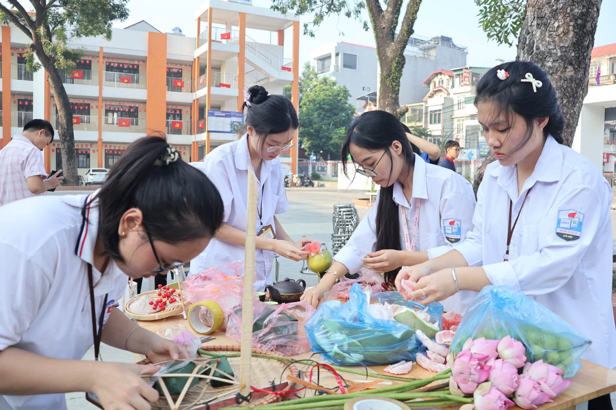 Đôi bàn tay khéo léo của các nữ sinh trường Hoài Đức A cẩn thận chuẩn bị từng chi tiết hoa sen, quả bưởi cho mâm cỗ truyền thống.