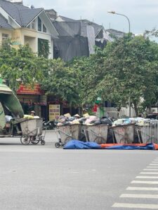Hàng loạt xe gom rác đẩy tay chất đầy phế thải sinh hoạt xếp thành hàng dài ngay mép đường ngã tư Lê Trọng Tấn.