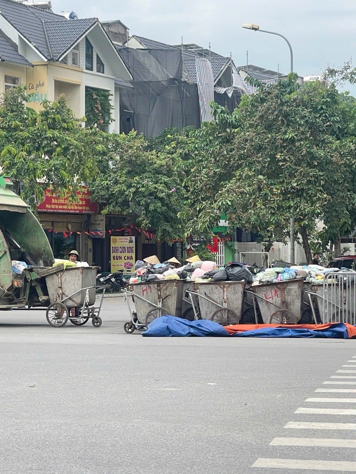 Hàng loạt xe gom rác đẩy tay chất đầy phế thải sinh hoạt xếp thành hàng dài ngay mép đường ngã tư Lê Trọng Tấn.