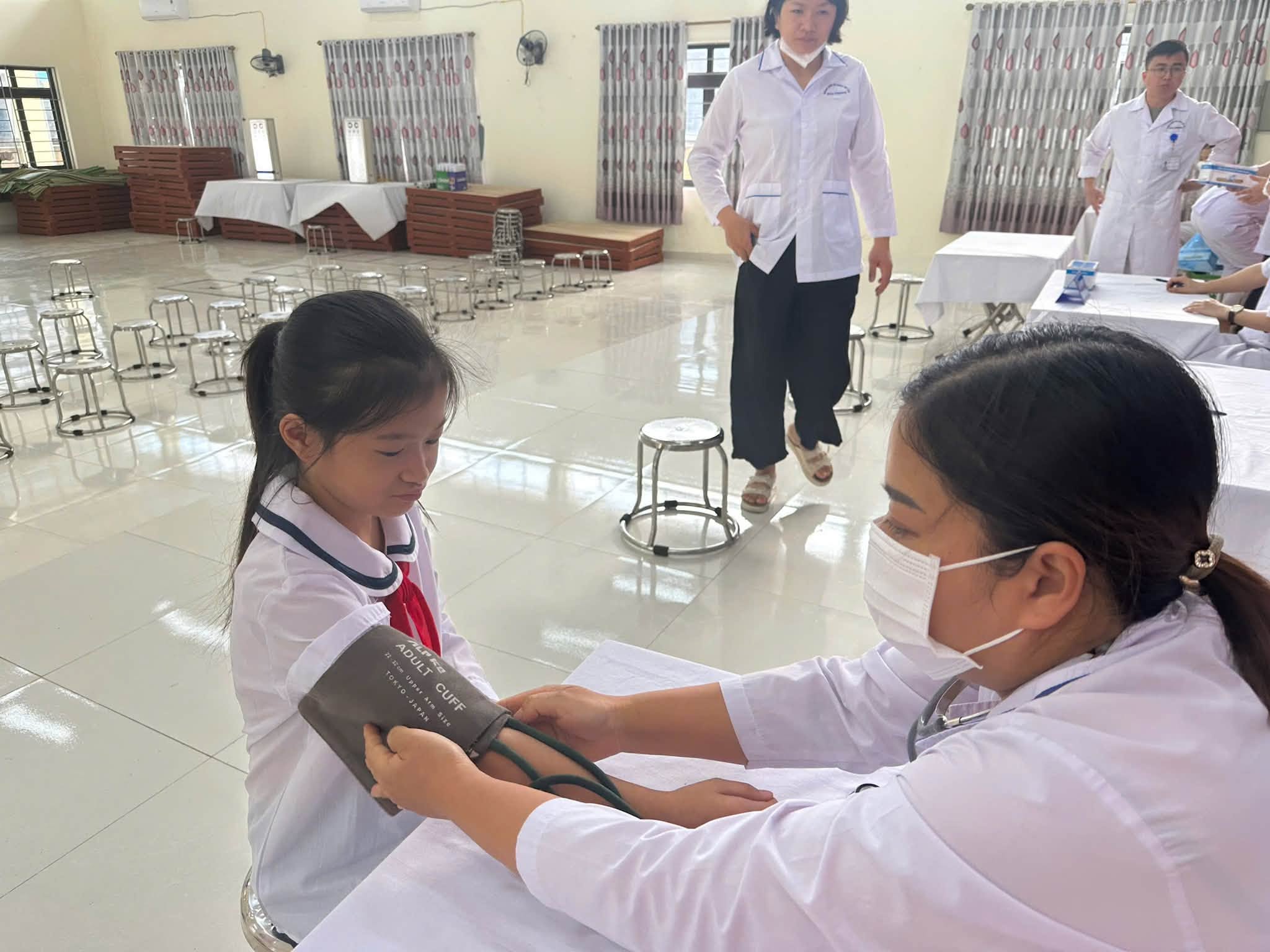 Bác sĩ Trung tâm Y tế An Lão ân cần kiểm tra huyết áp và nhịp tim cho học sinh.