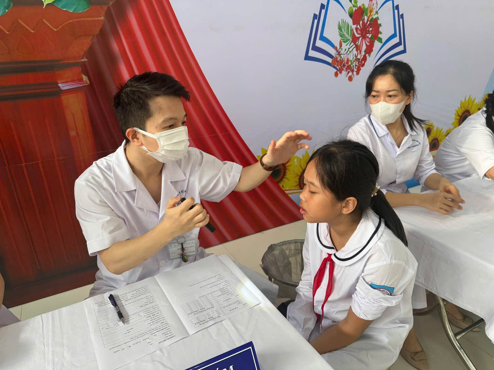 Bác sĩ chuyên khoa tỉ mỉ kiểm tra họng và răng miệng bằng thiết bị chuyên dụng.