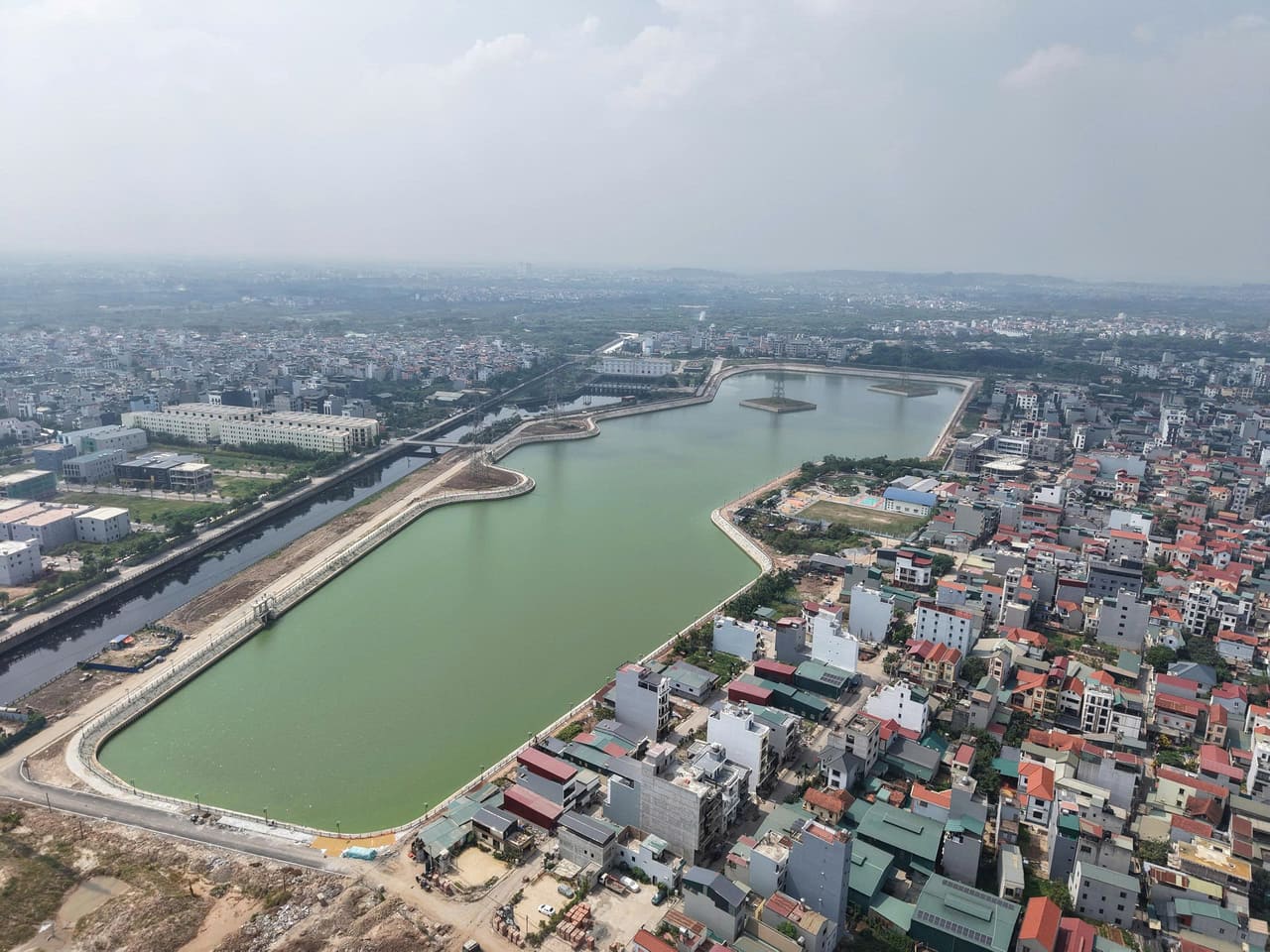 Hồ điều hòa nằm sát cạnh tuyến kênh dẫn về trạm bơm tiêu thoát nước.