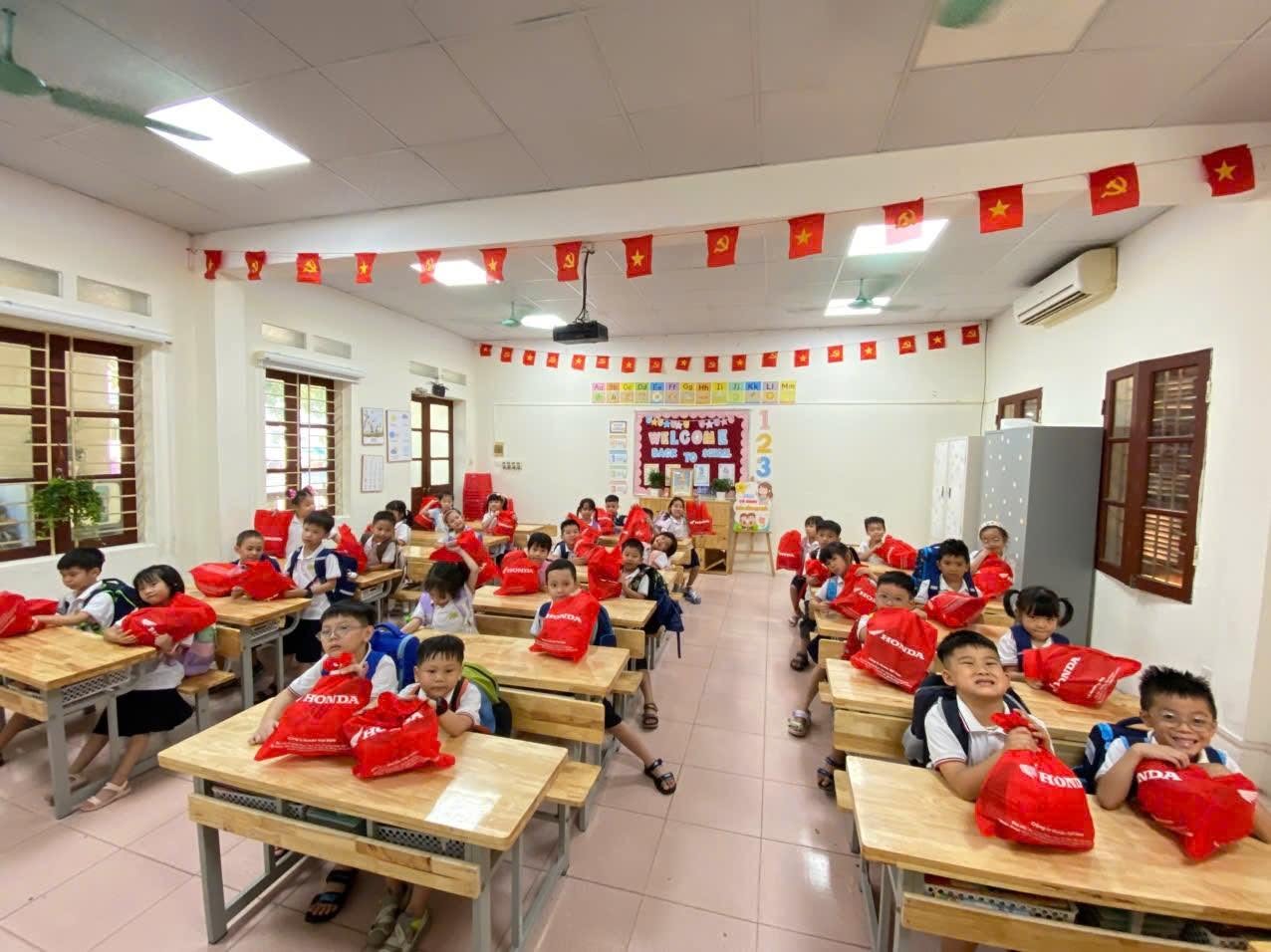 Niềm vui sướng, rạng rỡ của các bạn nhỏ trong lớp khi nhận được túi quà mũ bảo hiểm từ Honda.